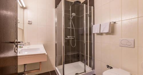 a bathroom with a shower with a toilet and a sink at Hotel Terra Nova in Novalja
