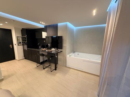 a kitchen with a tub and a table in a room at Soft Touch House in Strasbourg