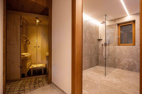 een badkamer met een douche met een glazen deur bij Sirona Stay - Private Spa Retreat with garden, garage and Bolzano-Card in San Genesio Atesino