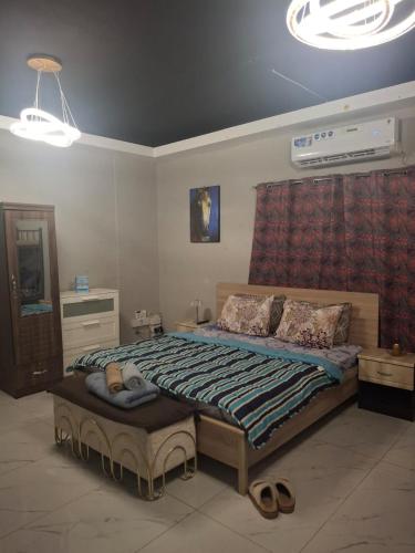 a bedroom with a bed with shoes on it at Cozy Corner 2024 in Abu Dhabi