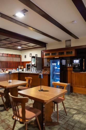 a restaurant with tables and chairs and a kitchen at Gasthof zum goldenen Schiff - Lehmzimmer Sand in Marktbreit