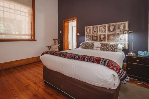 a bedroom with a large bed with a large headboard at Acorn Guest House in George