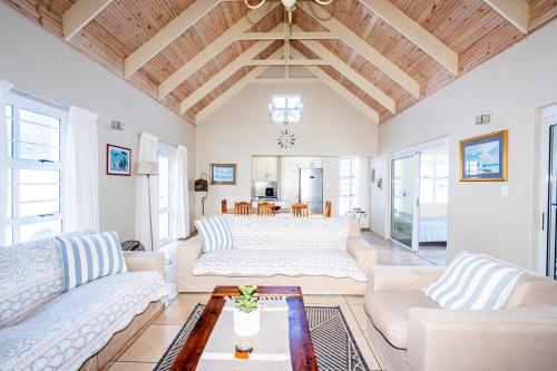 een woonkamer met twee witte banken en een tafel bij The Pelican in Langebaan