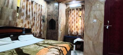 una camera da letto con un letto e una parete di legno di Hotel O new A.p galaxy a Juhi Bari