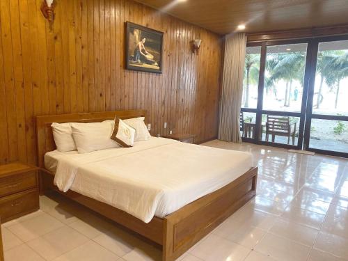a bedroom with a large bed with wooden walls at Tan Son Nhat Con Dao Resort in Con Dao