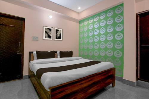 een slaapkamer met een bed en een groene muur bij SPOT ON Hotel Brocode in Dānāpur