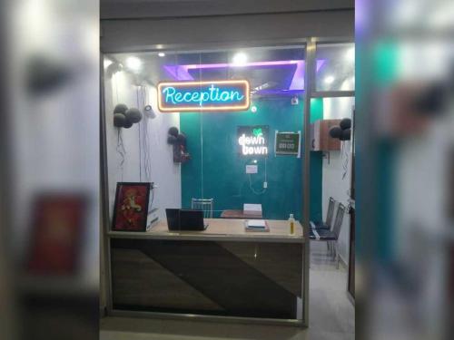 a reception desk in a room with a neon sign at Hotel O Downtown Rooms & Banquet in Darbhanga