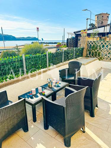 eine Terrasse mit Tischen und Stühlen und Meerblick in der Unterkunft Violetta 1 in Campese