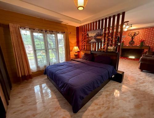 een slaapkamer met een blauw bed in een kamer bij Lanna Maple House in Ban Thap Dua