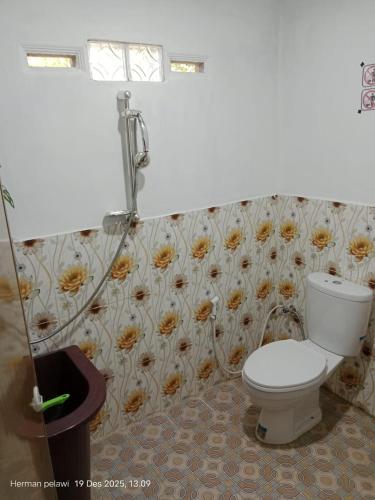 a bathroom with a toilet and a flower wallpaper at Batu Katak Jungle River & Trekking in Bukit Lawang