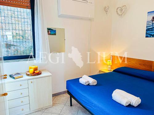 ein Schlafzimmer mit einem blauen Bett, einer Kommode und einem Fenster in der Unterkunft Raffaella 2 in Campese