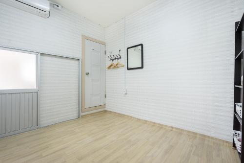 an empty room with a white wall and a door at Yours Guesthouse in Tongyeong in Tongyeong