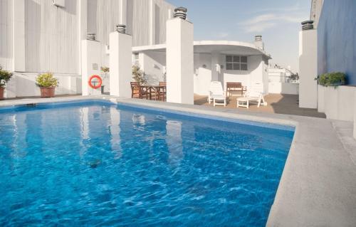 a large blue swimming pool in front of a house at Onix Fira in Barcelona