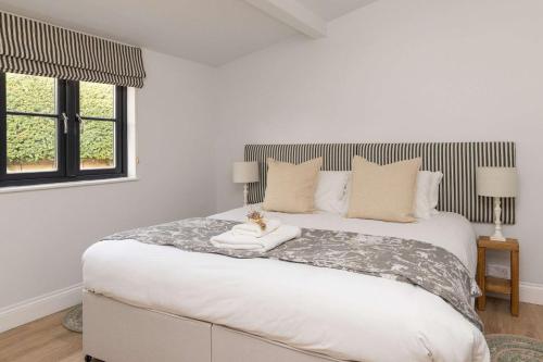 a bedroom with a large white bed with a window at Sidlesham Hideaway Logburner & Garden in Donnington