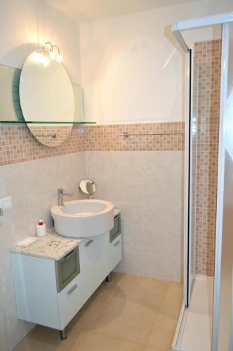a bathroom with a sink and a mirror and a shower at Casa Leone 1 in Caorle