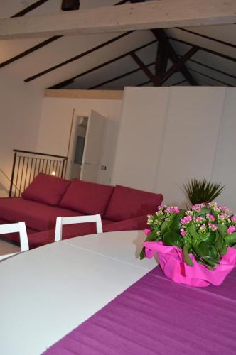 a table with a pink bowl of flowers on it at Casa Leone 1 in Caorle