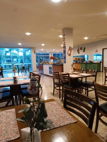 um restaurante com mesas e cadeiras de madeira e uma cafeteria em Hotel GAPH Maringa - Economico Mini Resort em Maringá