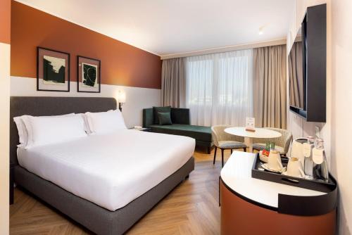 a hotel room with a bed and a living room at Crowne Plaza Padova by IHG in Padova