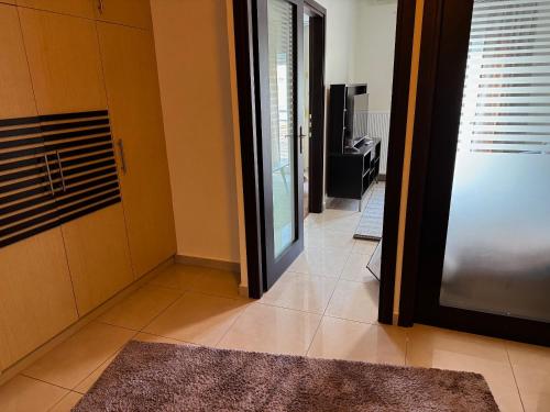 un couloir avec une porte coulissante en verre et un salon dans l'établissement Lithaios River Appartment, à Tríkala