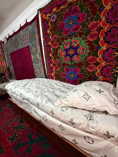 een slaapkamer met een bed met een kleurrijke muur bij Cheber Guest House 