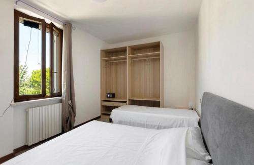 una camera da letto con due letti e una finestra di La Terrazza Guest House a San Zeno