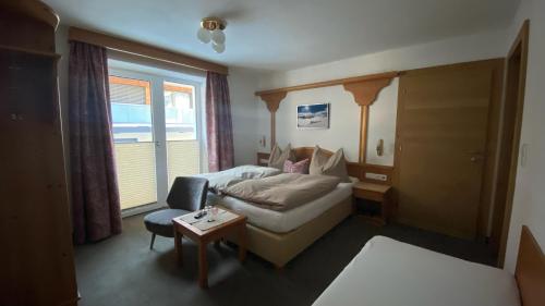 a hotel room with a bed and a chair at Haus Stockibach in Sankt Anton am Arlberg
