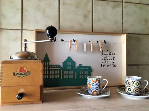two coffee cups and a box on a counter at Ferienwohnung Diesbrunnen in Ebermannstadt