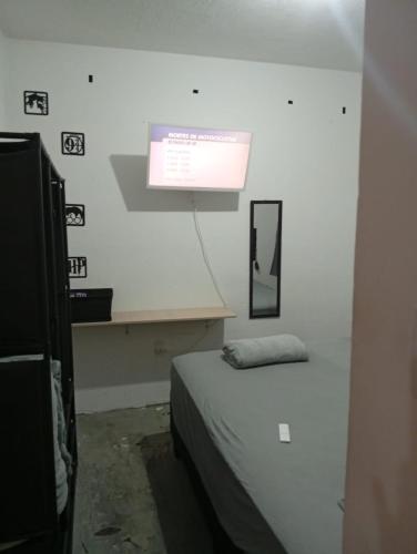 a room with a bed and a sign on the wall at Apartamento Serena in Votorantim