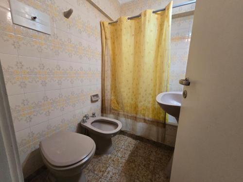 a bathroom with a toilet and a sink at La Perla Mar y Sol in Mar del Plata