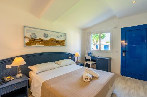 een slaapkamer met een groot bed en een blauwe deur bij Le Dune Beach Club in Torre Faro