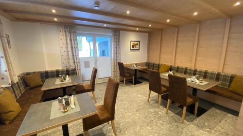 een restaurant met tafels en stoelen en een raam bij Haus Stockibach in Sankt Anton am Arlberg