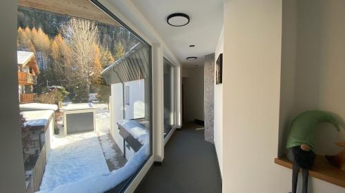 a room with a large window with a winter view at Haus Stockibach in Sankt Anton am Arlberg