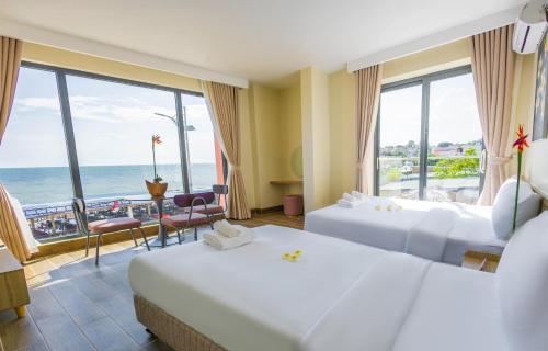 a hotel room with two beds and a view of the ocean at Chăm Charm Mũi Né, Phan Thiết in Mui Ne