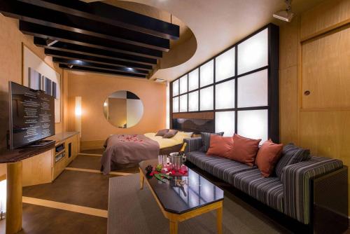 a living room with a couch and a table at HOTEL C-L'esapce in Honjo