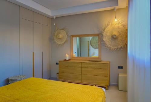 a bedroom with a yellow bed and a mirror at Charming Seaside Apartment with Pool & Direct Beach Access in Agadir nʼ Aït Sa