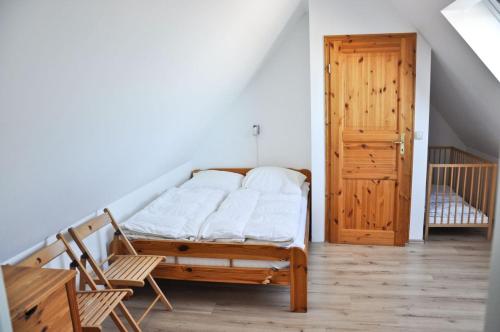 een slaapkamer met een bed en een houten deur bij Hirtenwohnung im Arbeiterhaus in Braunsberg