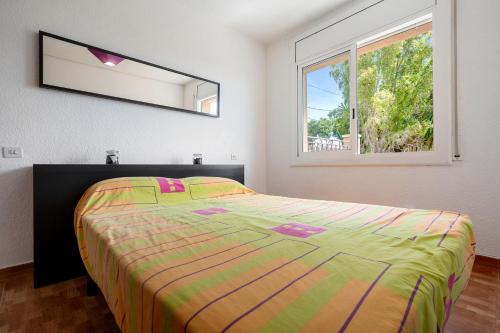 ein Schlafzimmer mit einem Bett und einem Spiegel an der Wand in der Unterkunft Apartamento Segur Calafell in Calafell