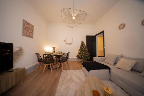 - un salon avec un canapé et un arbre de Noël dans l'établissement L'Élégance – Cosy & Chill, à Chambéry