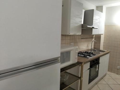 une cuisine avec des armoires blanches et un four à plaques de cuisson dans l'établissement Casa Ciuccetti, à Baldichieri