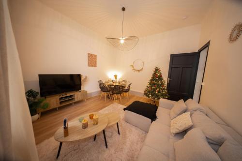 - un salon avec un canapé et un arbre de Noël dans l'établissement L'Élégance – Cosy & Chill, à Chambéry