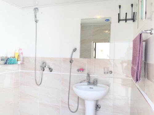 a bathroom with a sink and a shower at Yours Guesthouse in Tongyeong in Tongyeong