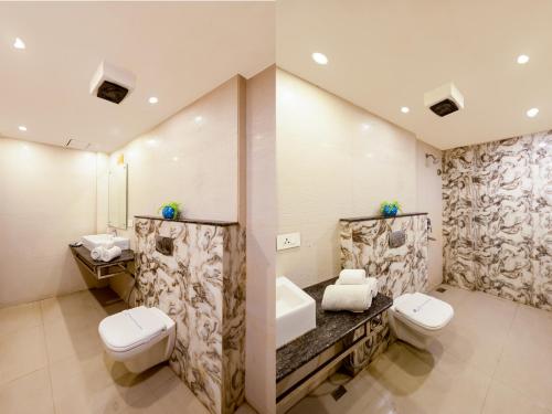 a bathroom with two toilets and a sink at Hotel Mayur - New Delhi City Centre in New Delhi