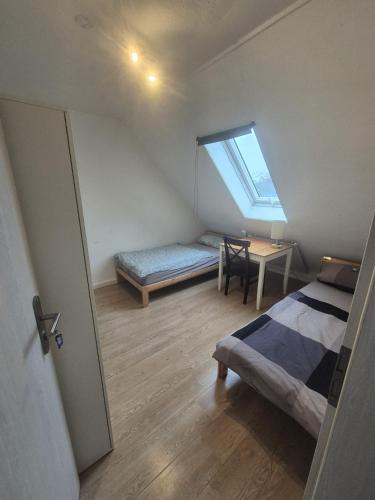 een slaapkamer met een bed, een tafel en een raam bij Süder11 - ApartD in Eddelak