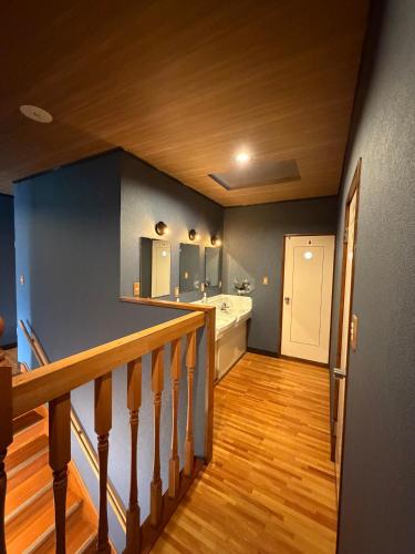 a room with a staircase with a bathroom and a sink at Nozawa Nest in Nozawa Onsen