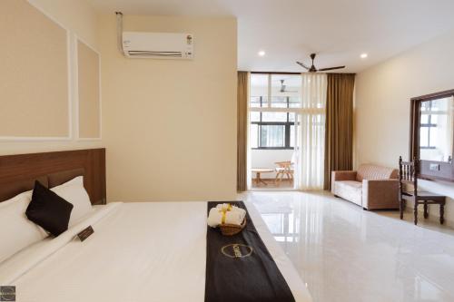 een slaapkamer met een bed en een woonkamer bij Reunion De Homes - Premium Suites in Udupi