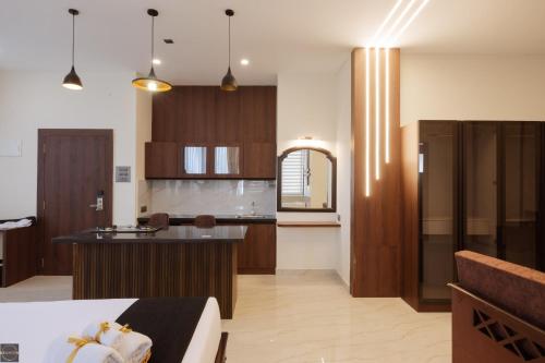 een keuken met houten kasten en een keukeneiland bij Reunion De Homes - Premium Suites in Udupi