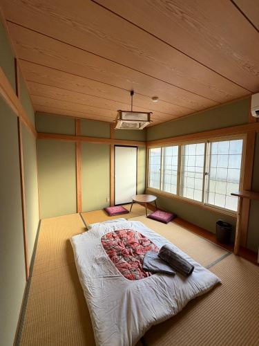 a room with a bed in a room with windows at Nozawa Nest in Nozawa Onsen
