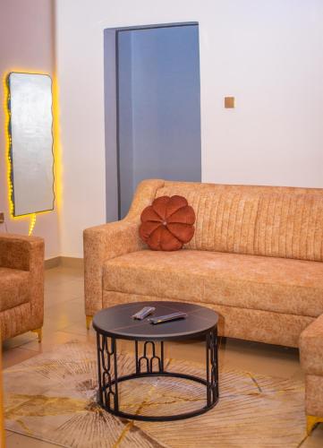 a living room with a couch and a table at Afro-D Apartment in Asagba