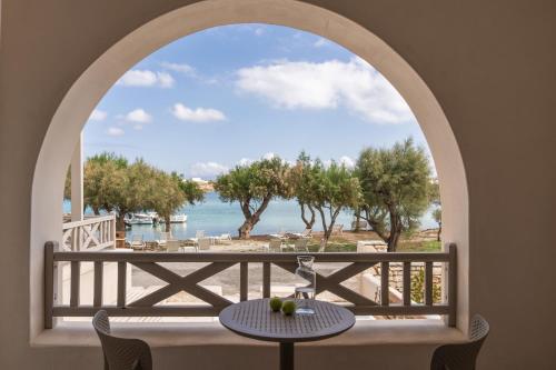ein Torbogen mit Tisch und Blick aufs Meer in der Unterkunft Salt Suites Paros in Naoussa