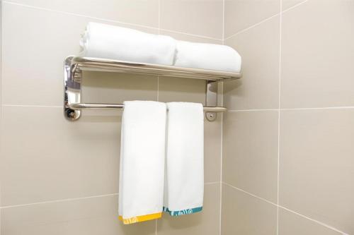 a group of towels hanging on a rack in a bathroom at City Comfort Inn Chengdu Longquanyi District Beijing Road in Chengdu